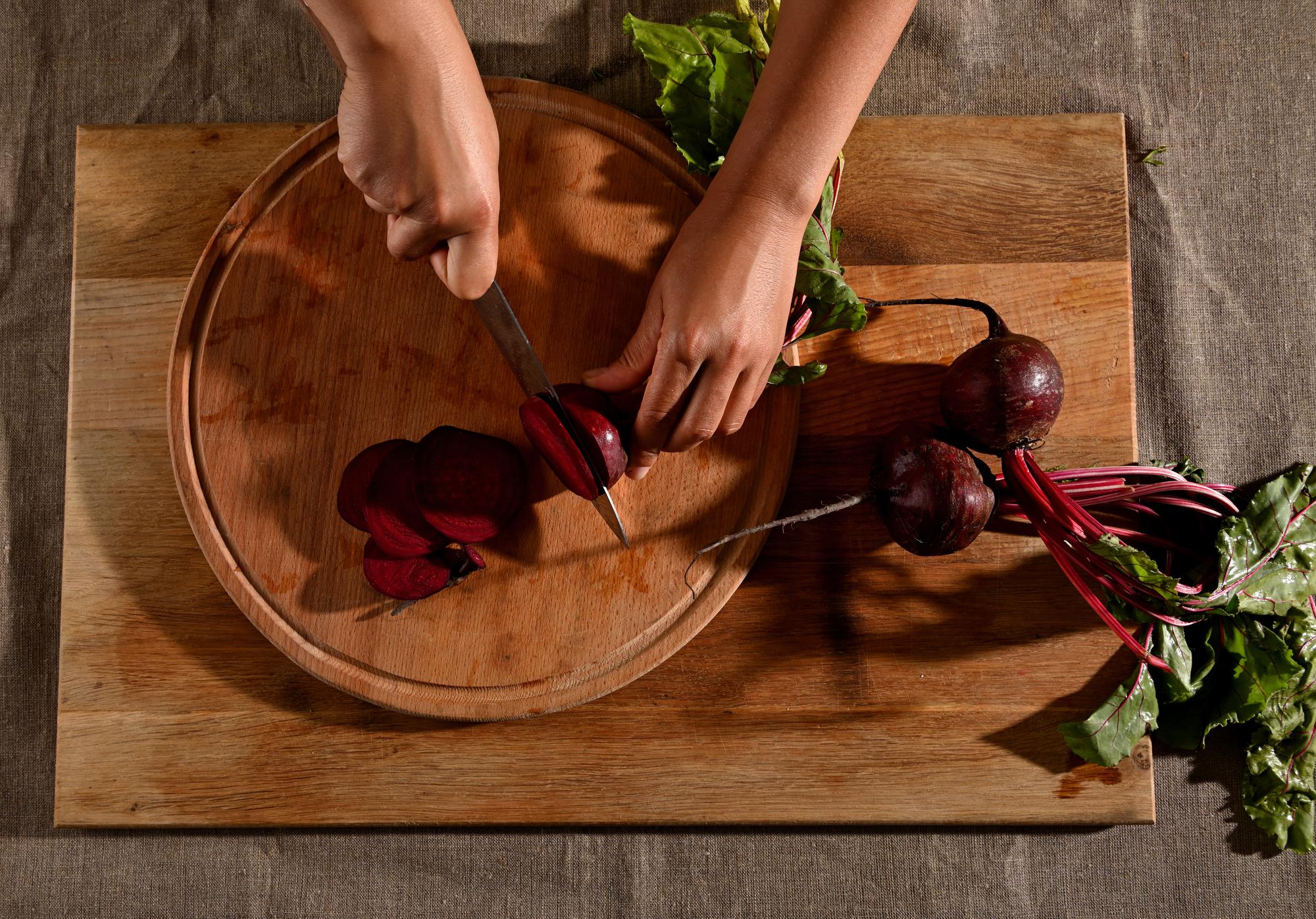 hands chopping vegetables on board
